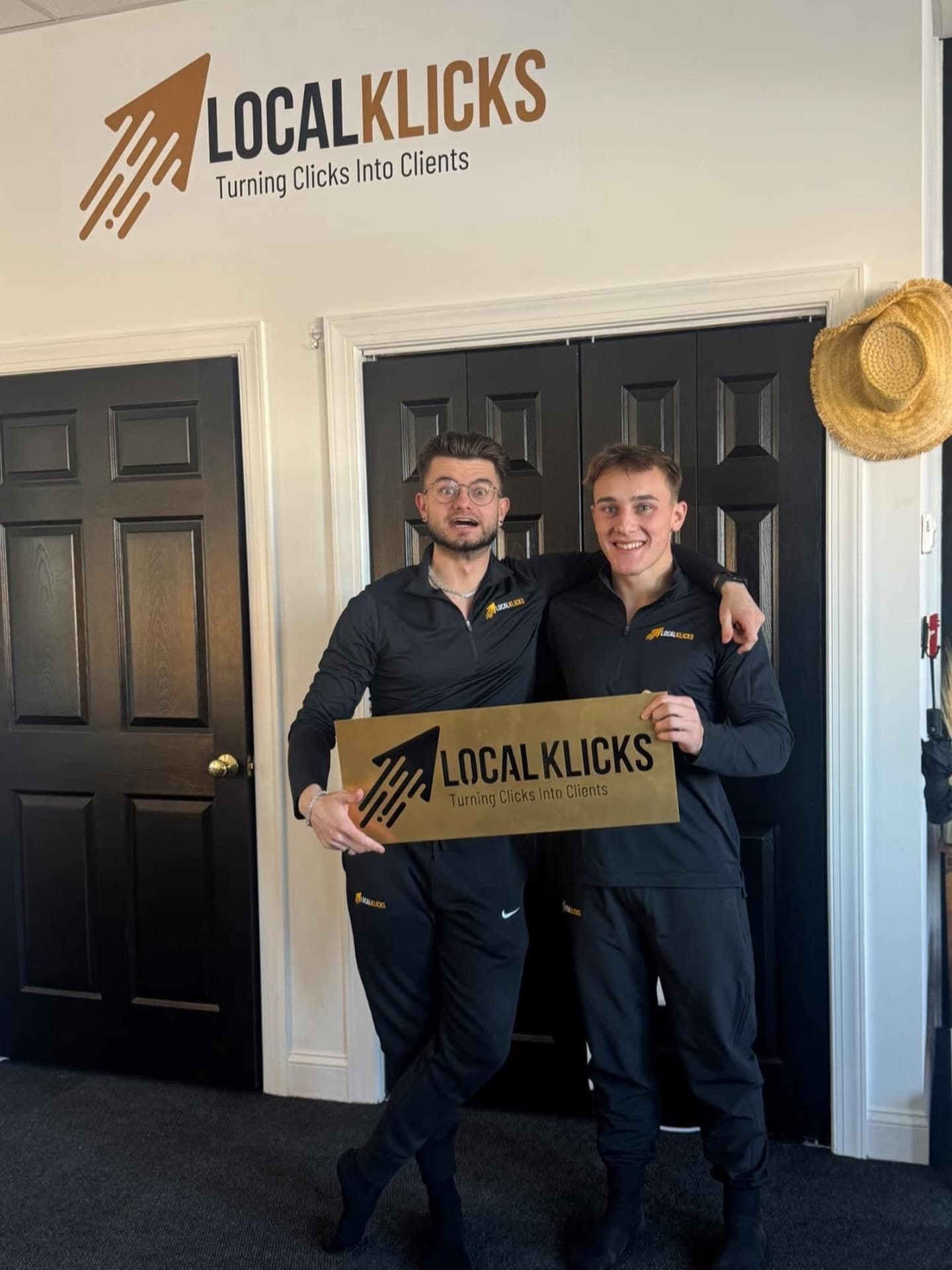Sean Hodel and Zackary Michael holding a Local Klicks sign in the Local Klicks office in Winchester